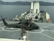 Soldiers with 2nd Battalion, 2nd Aviation Regiment, 2nd Combat Aviation Brigade exit a U.S. Army UH-60M Black Hawk helicopter after single-spot deck-landing qualifications on prepositioning ship USNS Dahl (T-AKR 312), March 7. (Courtesy photo)