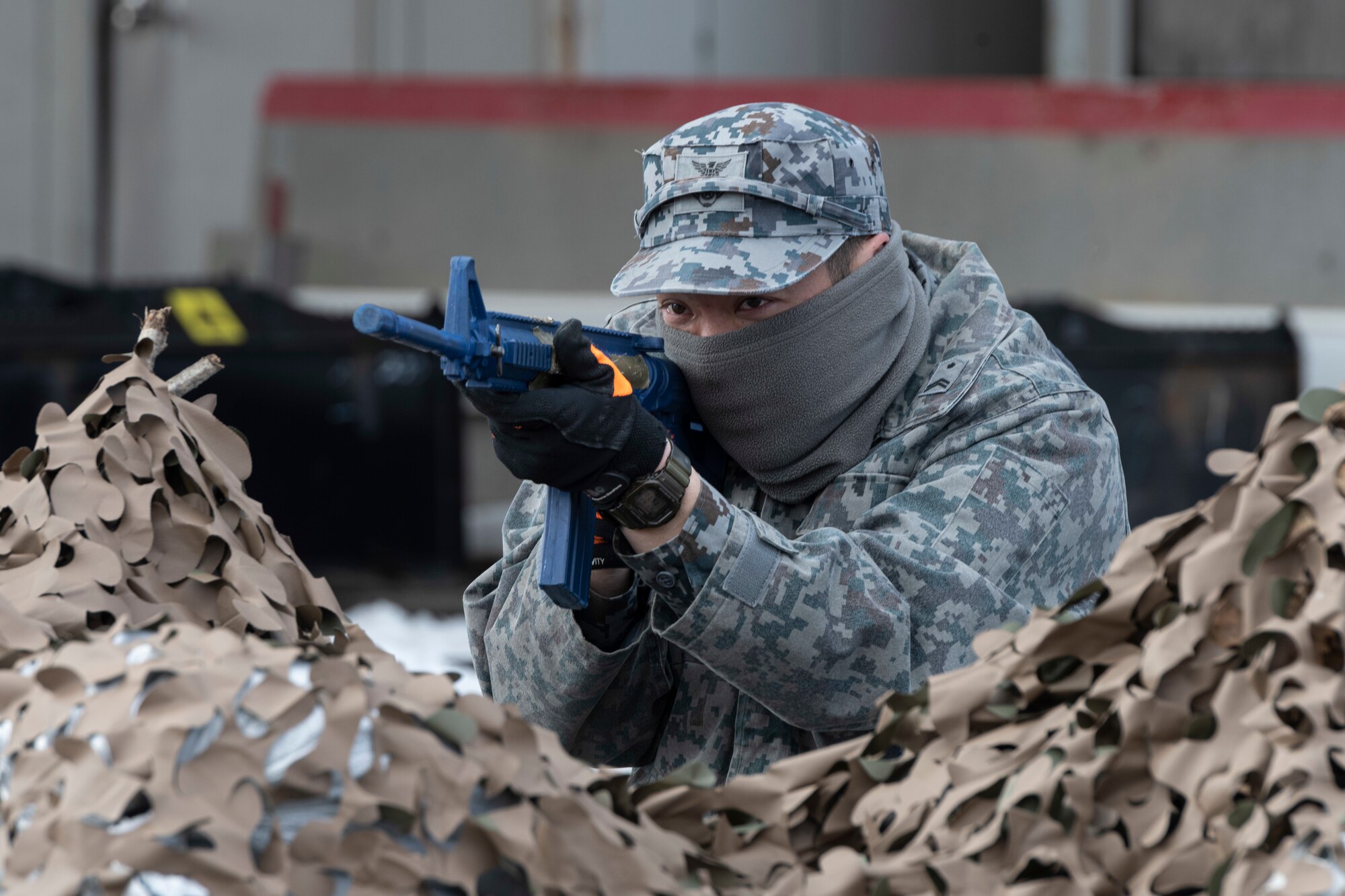 A Japan Air Self-Defense (JASDF) Airman aims his trainer rifle from a Defensive Fighting Position (DFP) during a bilateral Multi-Capable Airman (MCA) course at Misawa Air Base, Japan, March 8, 2024.