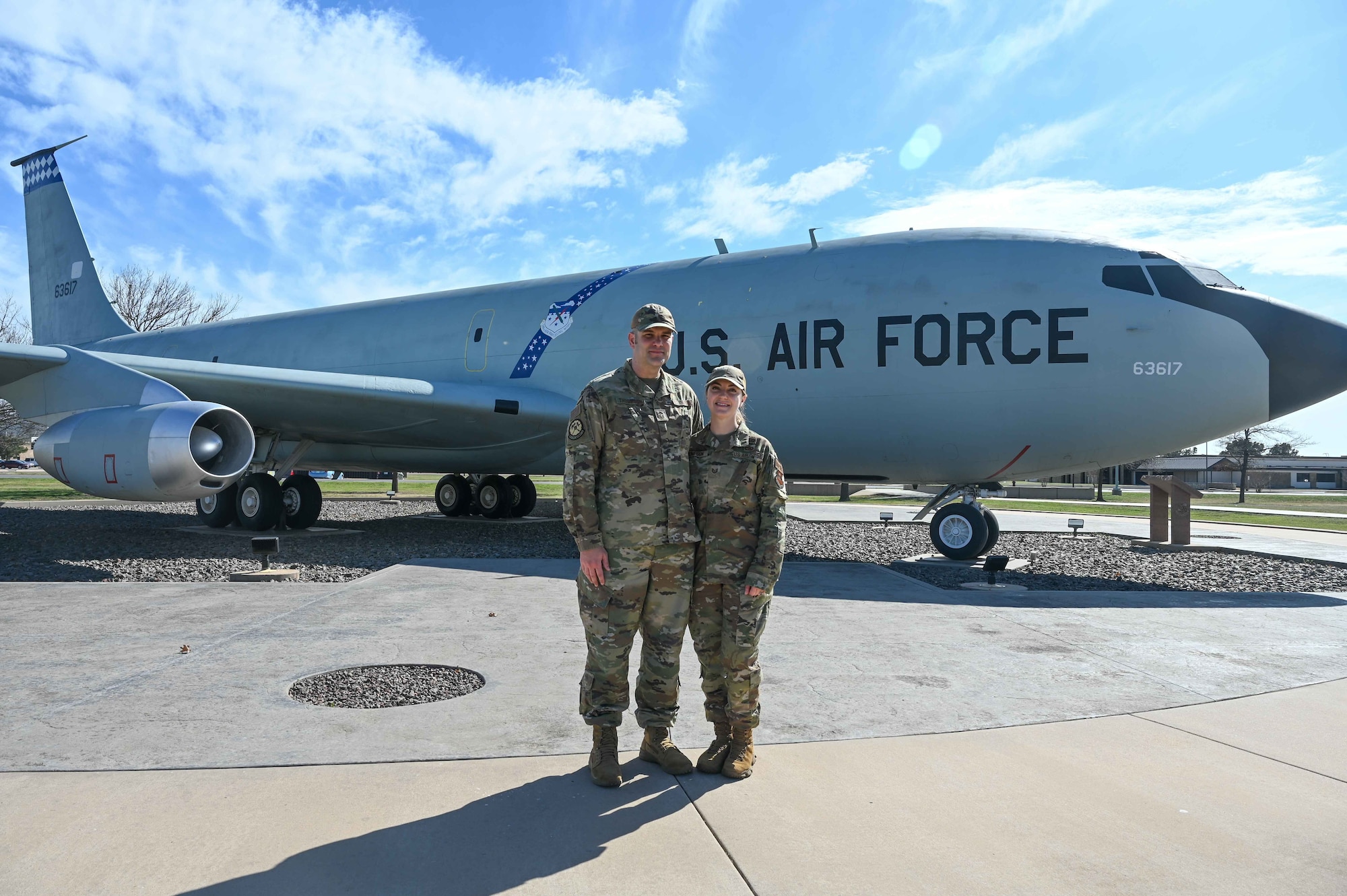 two people stand in front of plane