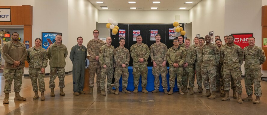 Team Minot Airmen pose for a photo at the kickoff event for the 2024 Air Force Assistance Fund campaign at Minot Air Force Base, North Dakota, March 11, 2024. The Air Force Assistance Fund provides aid to Airmen and their families to cover the cost of things such as emergency needs, educational assistance, and family support. (U.S. Air Force photo by Airman 1st Class Kyle Wilson)