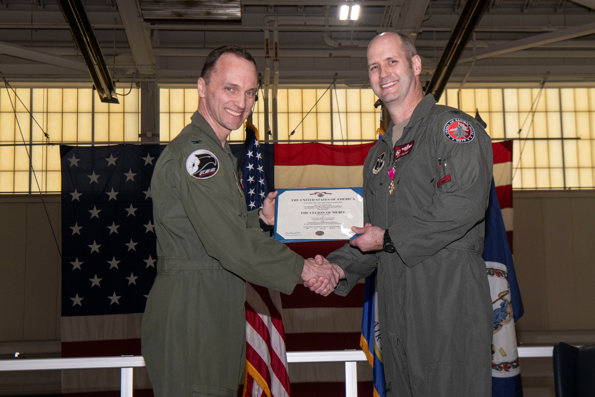 2 Air Force officers holding Legion of Merit certificate