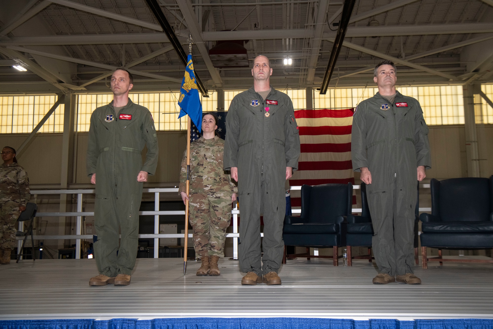 4 Air Force members standing at attention on stage