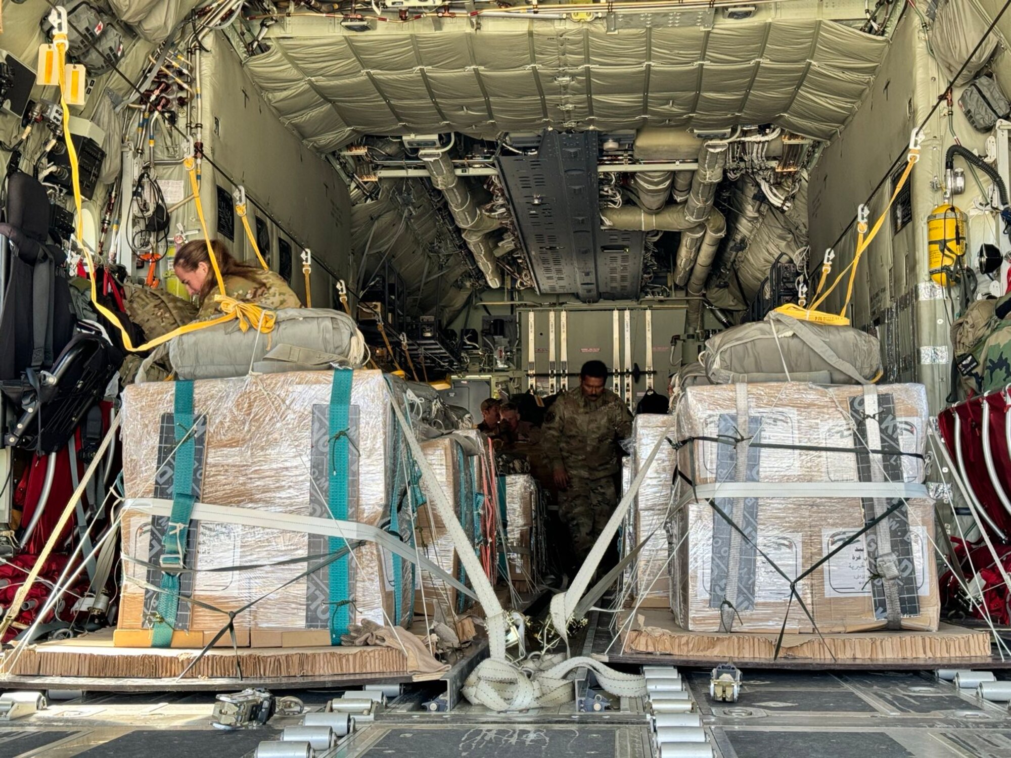 Loadmasters prepare humanitarian aid destined for Gaza on a HC-130J.