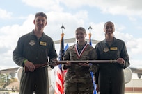 A person poses for a photo with an award.