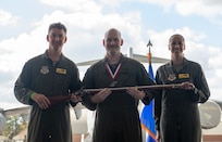 A person poses for a photo with an award.