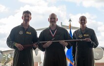 A person poses for a photo with an award.