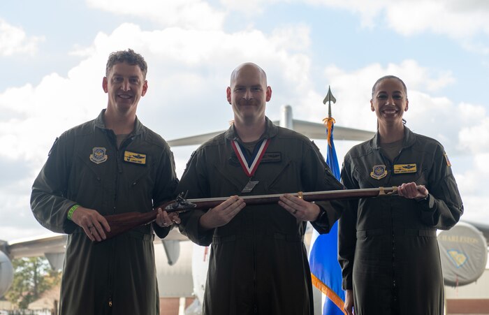 A person poses for a photo with an award.
