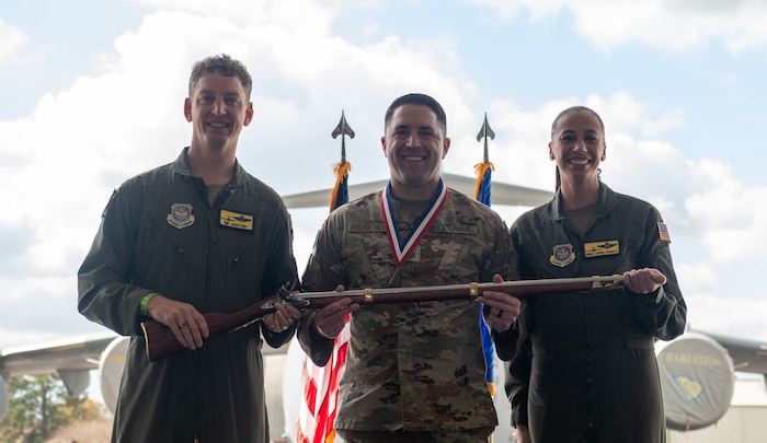 A person poses for a photo with an award.