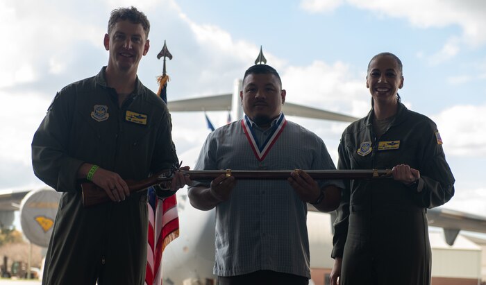A person poses for a photo with an award.
