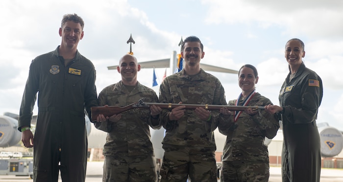 A person poses for a photo with an award.