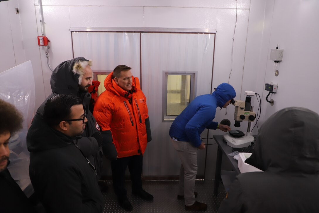 Dr. Ivan Beckman (orange coat), acting director of ERDC's Cold Regions Research and Engineering Laboratory (CRREL), and performer team members of the Ice Control for cold Environments (ICE) program inspect ice samples inside a ERDC-CRREL cold box.