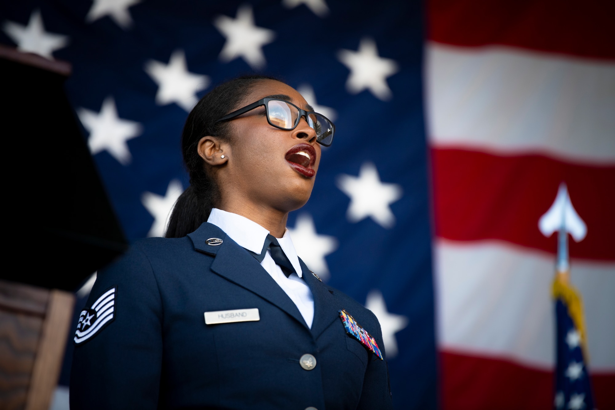 Tech. Sgt. Shaquanna Husband, 721st Contingency Response Squadron section chief of special teams, sings the national anthem for retired Chief Master Sgt. Paul Valenzuela during his retirement ceremony at Hangar 818 on Travis Air Force Base, Calif., March 8, 2024.