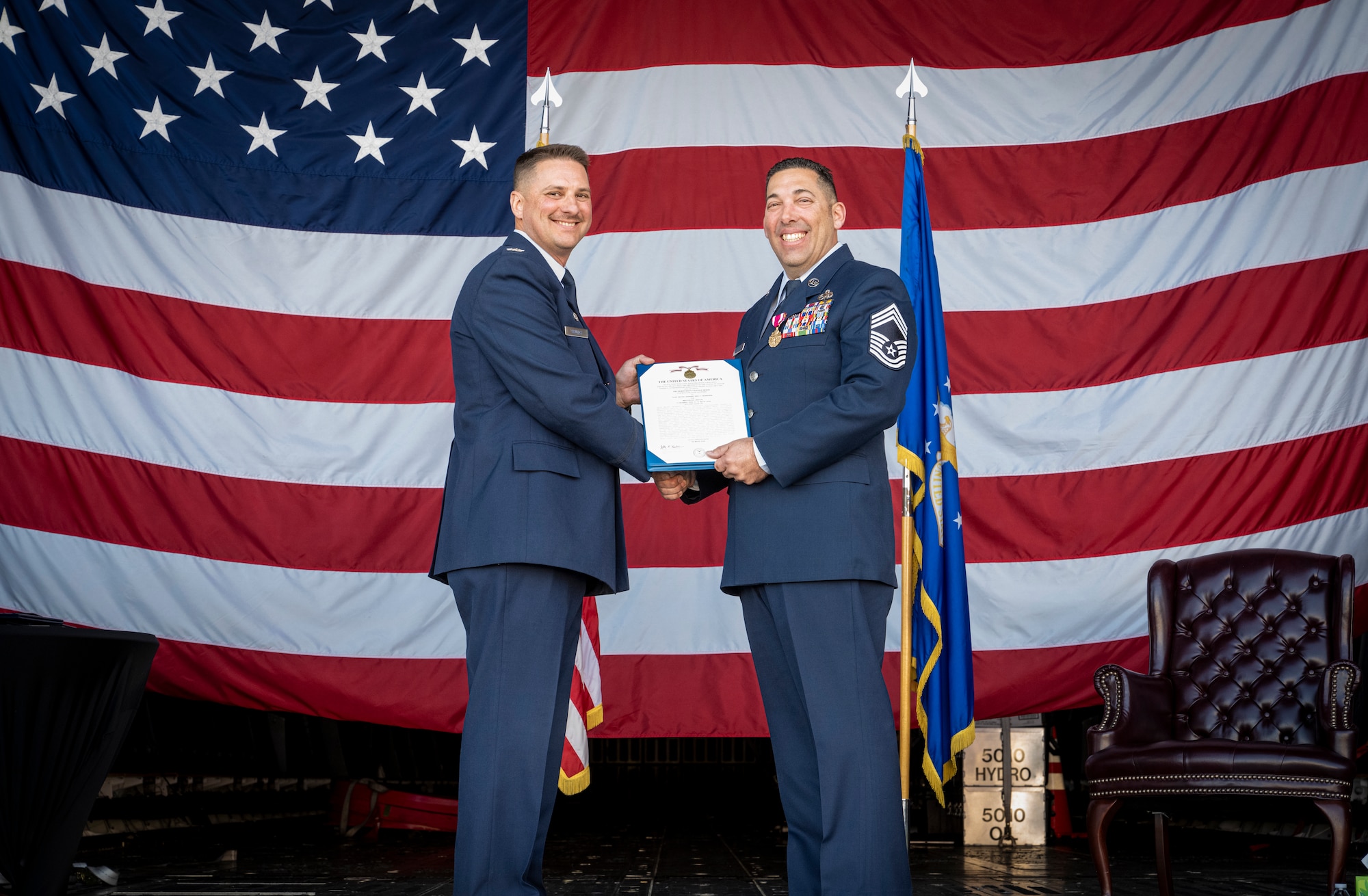 U.S. Air Force Col. Jeffrey Krulick, left, 821st Contingency Response Group commander, presents a meritorious service medal and certificate to Chief Master Sgt. Paul Valenzuela, right, 821st Contingency Response Squadron senior enlisted leader, after 30 years of honorable service to the USAF during his retirement ceremony at Hangar 818 on Travis Air Force Base, Calif., March 8, 2024.