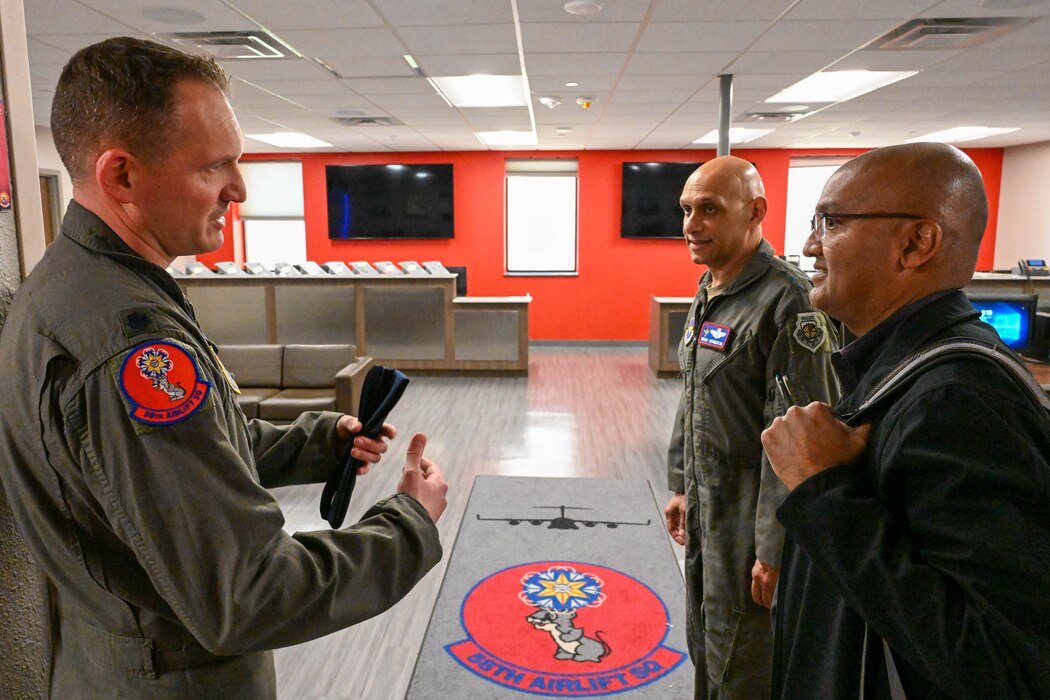 U.S. Air Force Lt. Col. Pete Bulinski, left, 58th Airlift Squadron commander, showcases the 58th AS building to Lt. Gen. Brian Robinson, center, commander of Air Education and Training Command, Dr. Sandeep Mulgund, right, Headquarters Air Force senior advisor to the deputy chief of staff for operations, at Altus Air Force Base, Oklahoma, March 7, 2024. Mulgund visited Altus as part of his integration with AETC’s leaders regarding the various training missions and curricula.  (U.S. Air Force photo by Senior Airman Miyah Gray)