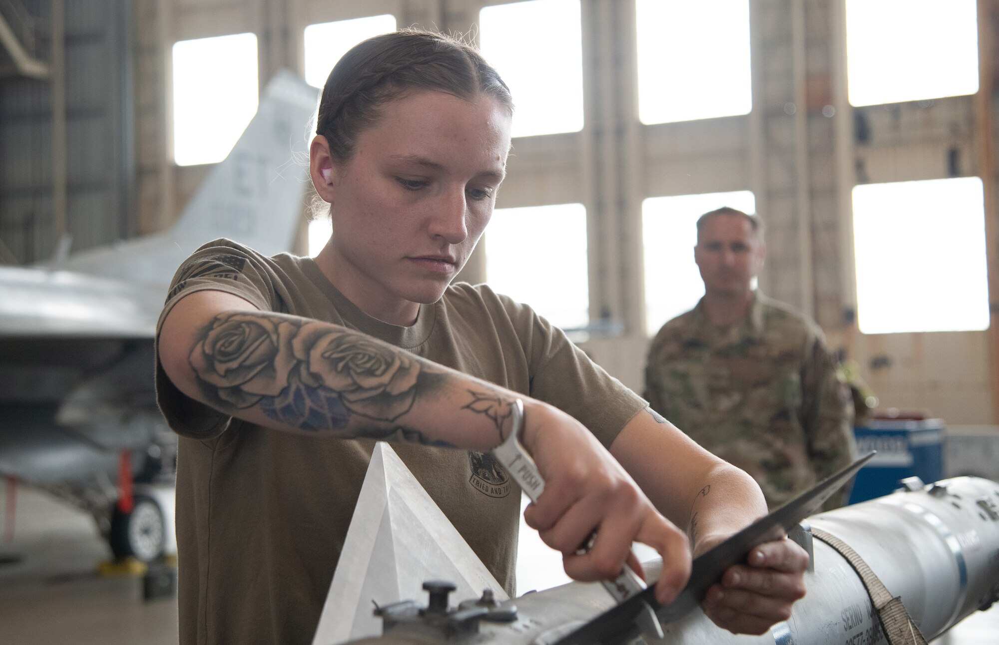A weapons load crew member, installs AIM-120 fins.