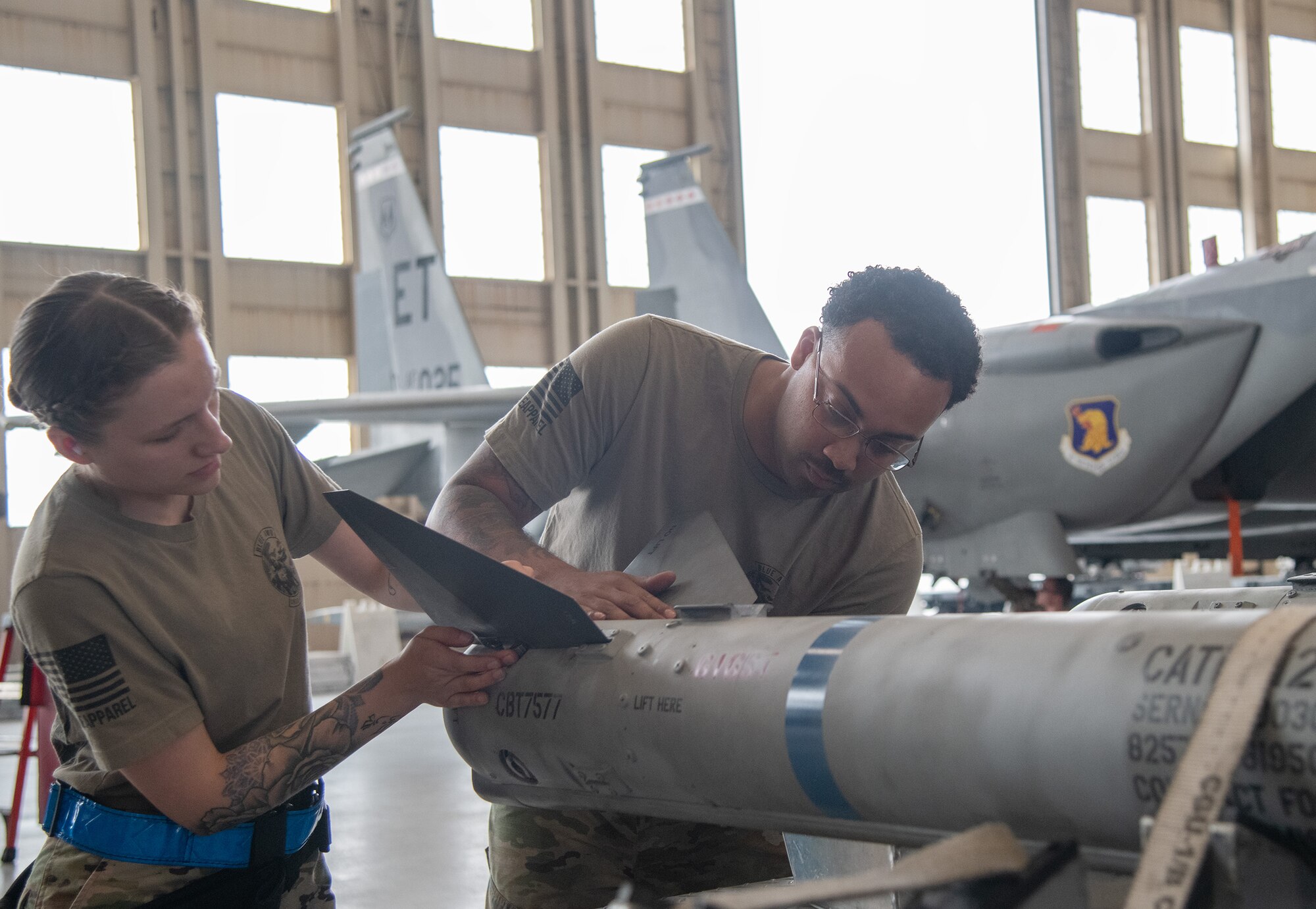 Weapons load crew members install  AIM-120 fins.