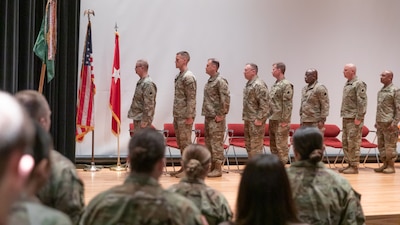 Leaders from the Illinois Army National Guard, the 933rd Military Company and their families stand during the playing on the National Anthem on March 9th during a welcome home ceremony at the College of Lake County, in Grayslake, Illinois.