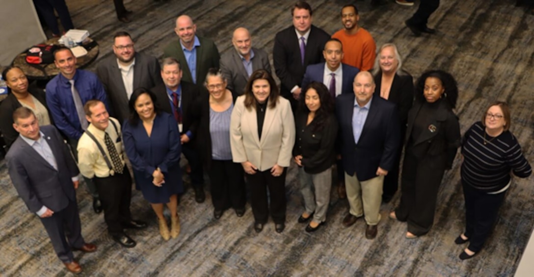 Group of professionally dressed people looking up at camera.