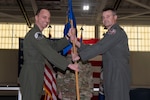 Two Air Force officers holding a guidon, smiling for photo