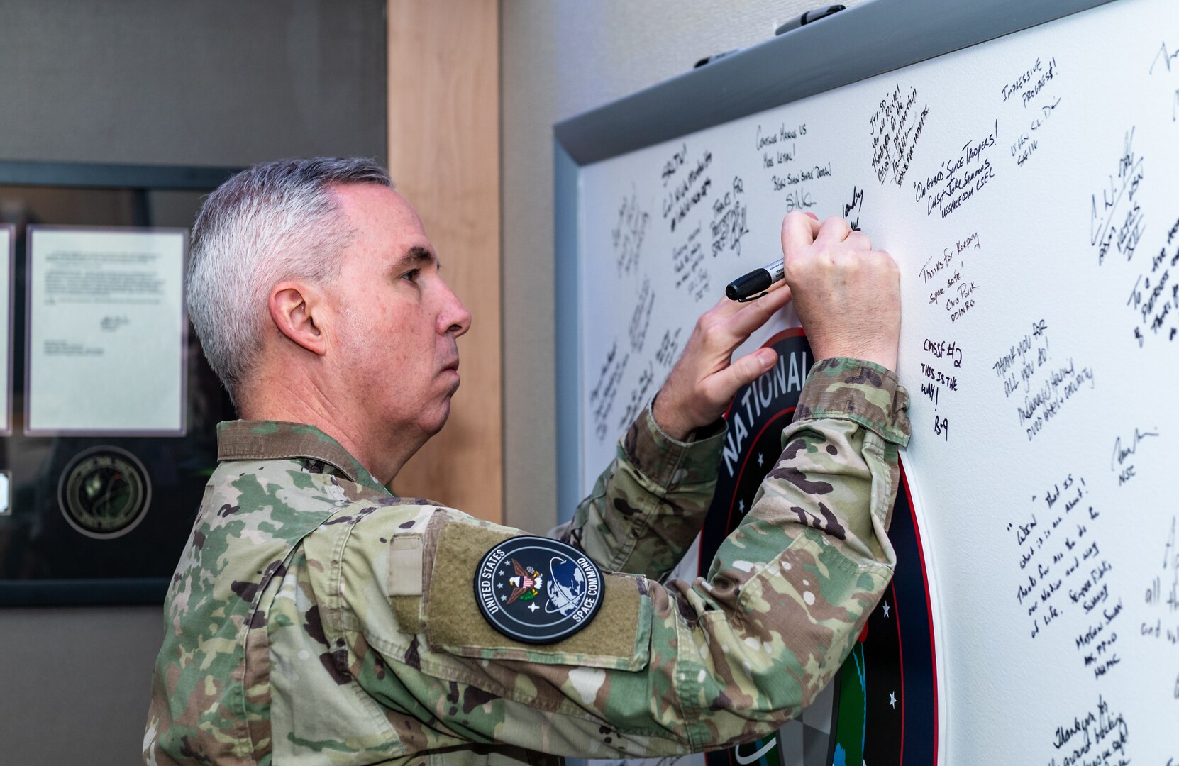 Man in military uniform signing board