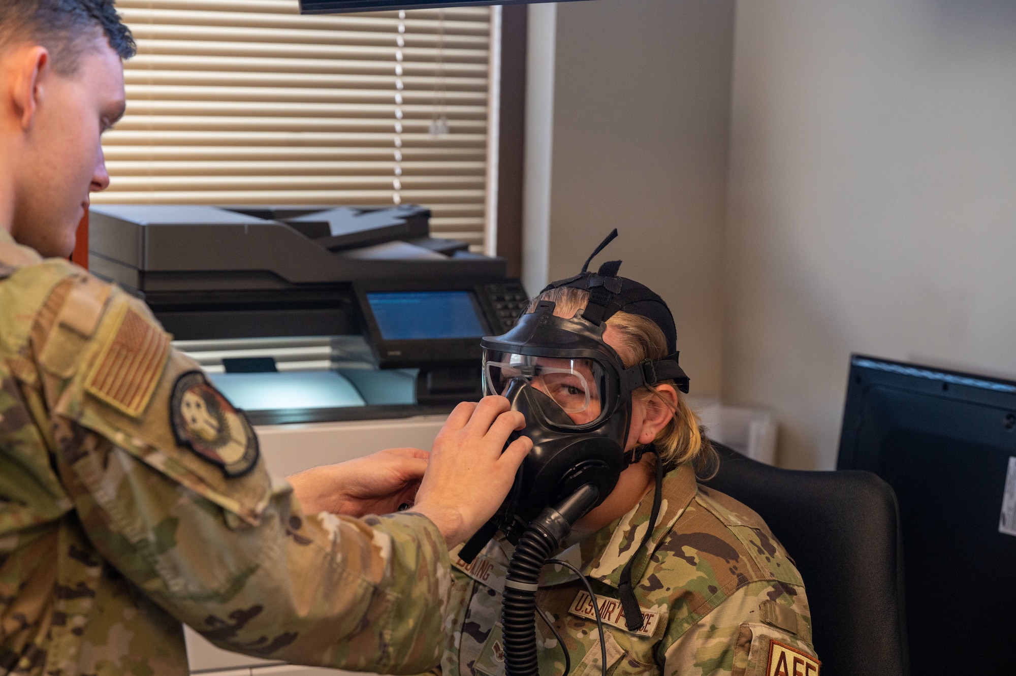 U.S. Air Force Airman 1st Class Elijah Bartley, 563rd Operations Support Squadron aircrew flight equipment specialist, left, assists Airman 1st Class Trinity Bowling, 563rd OSS aircrew flight equipment specialist, right, with a M69 Joint Service Aircrew Mask Strategic Aircraft respirator mask at Davis-Monthan Air Force Base, Ariz., March 5, 2024. Bartley and Bowling were participants of a new equipment training course featuring the M69 respirator mask. (U.S. Air Force photo by Airman 1st Class Robert Allen Cooke III)