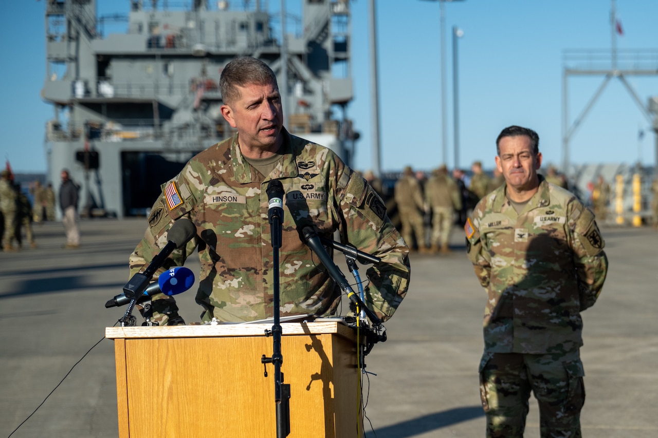 A soldier in uniform stands at a lectern.