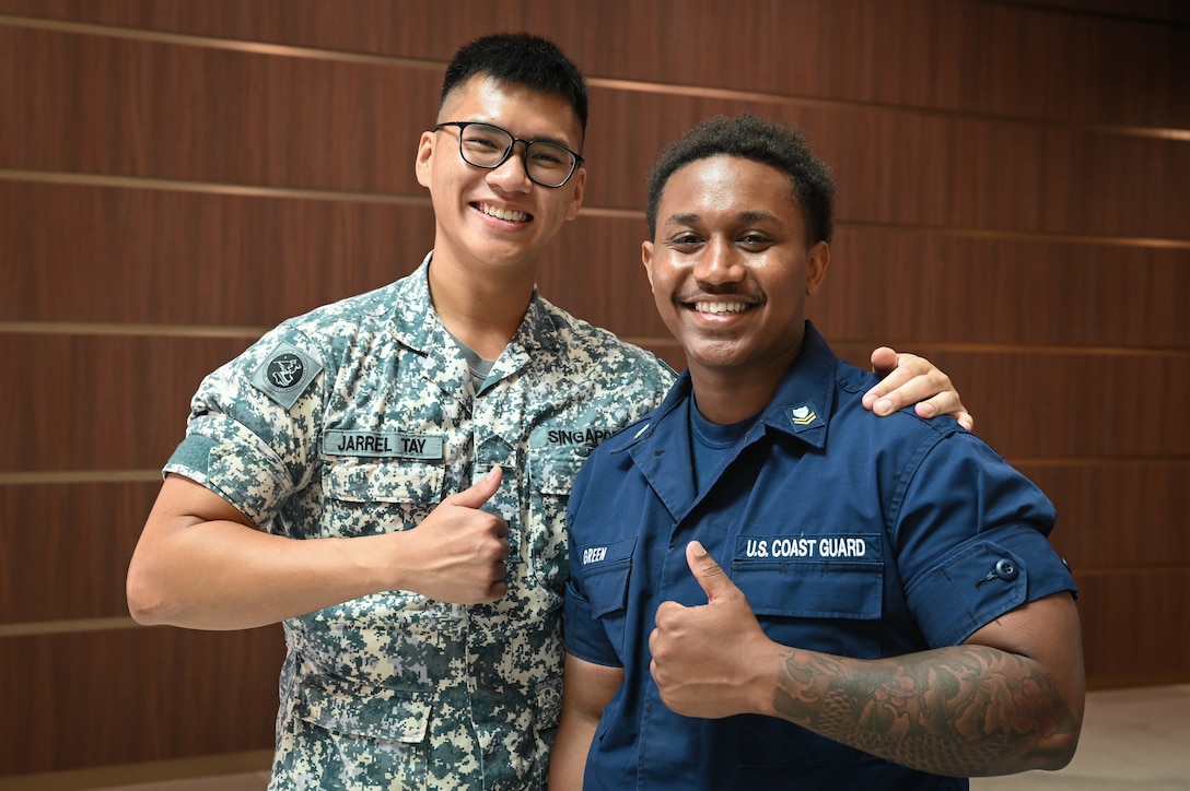 Petty Officer 2nd Class Dallas Green, a crewmember from U.S. Coast Guard Cutter Bertholf (WMSL 750), stands with a member of the Republic of Singapore Navy following a ceremony at the Changi Navy Base in Singapore, Feb. 26, 2024. Following the ceremony, crews from both the Bertholf and the Republic of Singapore Navy socialized about their experiences in their respective sea-going services. (U.S. Coast Guard photo by Petty Officer Steve Strohmaier)