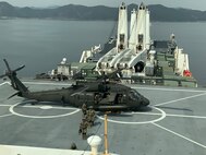 Soldiers with 2nd Battalion, 2nd Aviation Regiment, 2nd Combat Aviation Brigade exit a U.S. Army UH-60M Black Hawk helicopter after single-spot deck-landing qualifications on prepositioning ship USNS Dahl (T-AKR 312), March 7. (Courtesy photo)