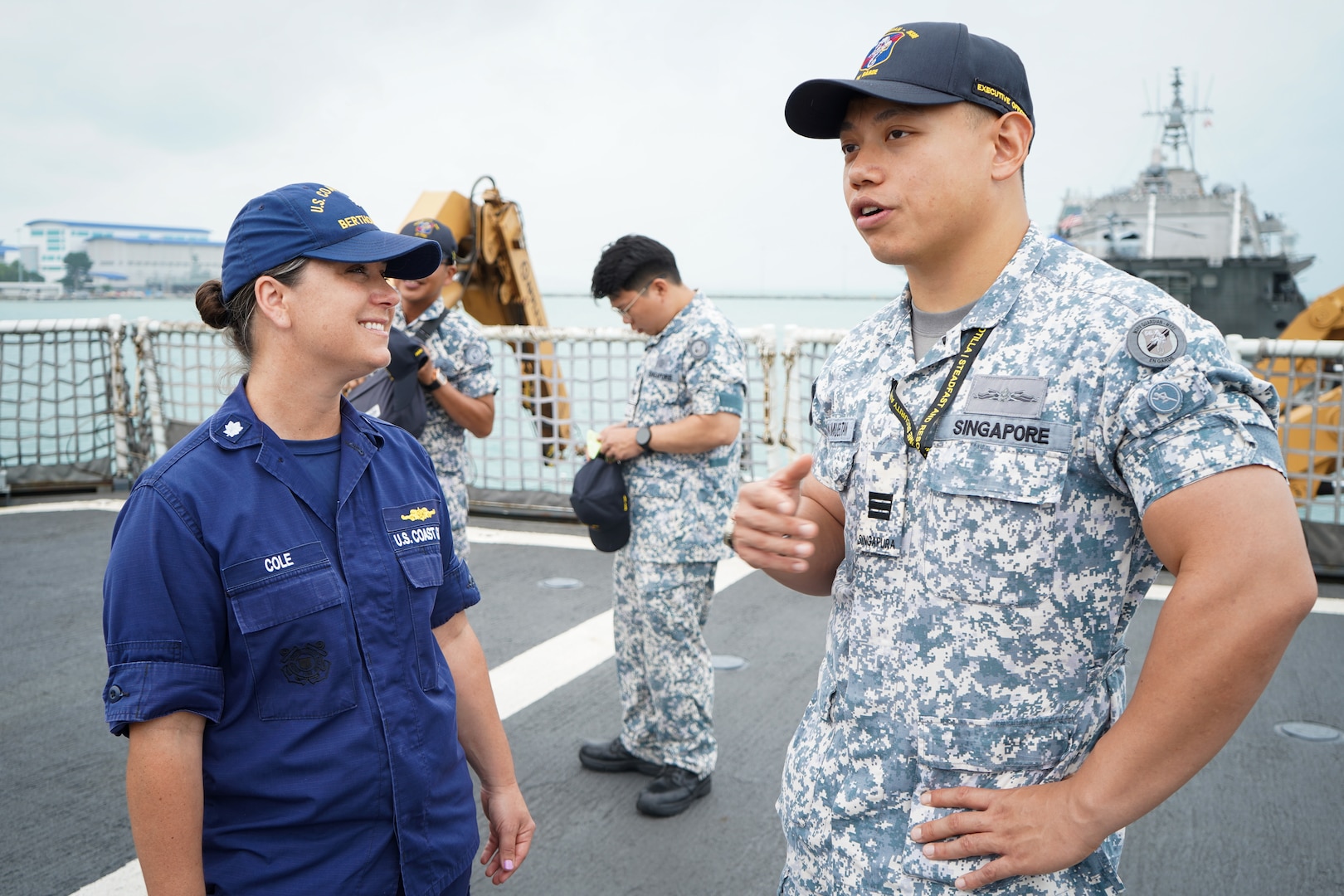 Cmdr. Leah Cole, executive officer, U.S. Coast Guard Cutter Bertholf (WMSL 750), speaks with her counterpart, the executive officer of the Republic of Singapore naval ship, Guardian, while the Bertholf was moored at Changi Naval Base, Feb. 27, 2024. The Navy crewmembers came aboard the Bertholf for a brief tour and to enjoy lunch with the crew. (U.S. Coast Guard photo by Petty Officer Steve Strohmaier)
