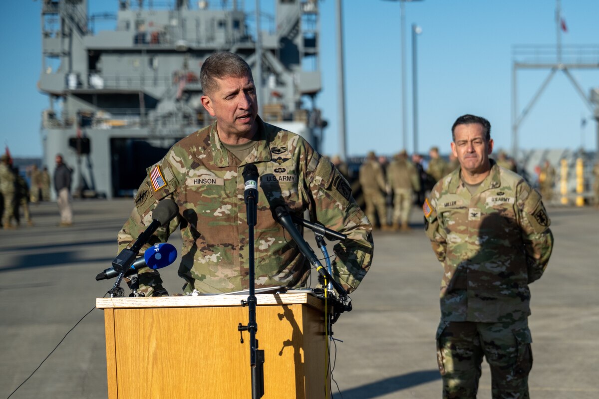 A soldier in uniform stands at a lectern.