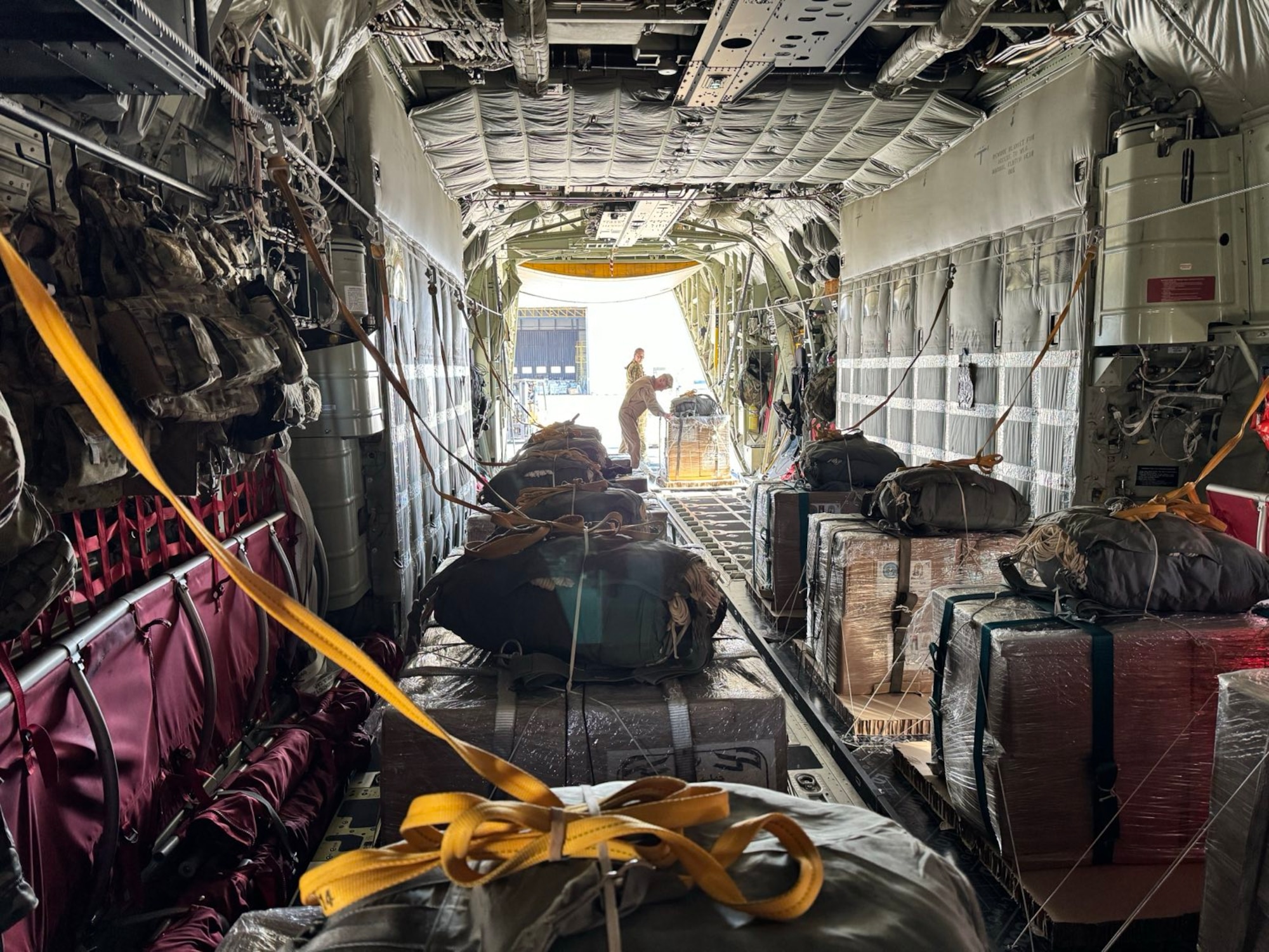 Loadmasters prepare humanitarian aid destined for Gaza onto a HC-130J aircraft.