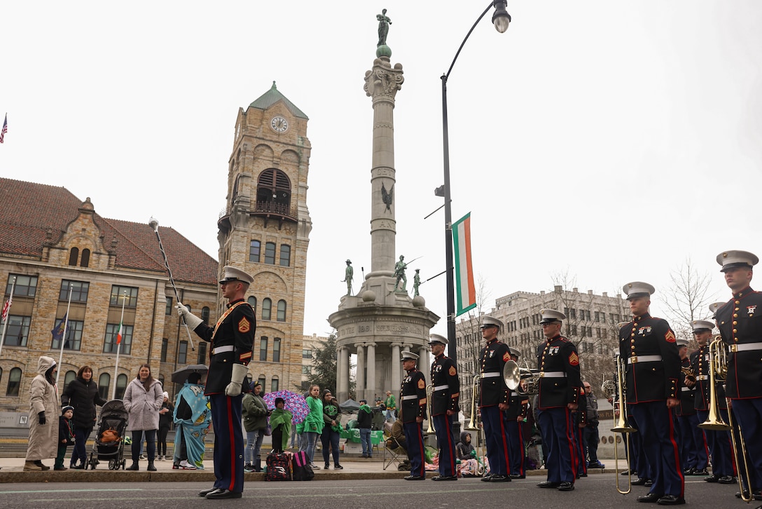 The Quantico Marine Band stand at attention during the St. Patricks’ Day Parade in Scranton, Pennsylvania, March 9, 2024. The band provides musical support that enhances community relations and troop morale, and promotes the Marine Corps recruiting program through events such as parades, concerts, and ceremonies. (U.S. Marine Corps photo by Lance Cpl. David Brandes)