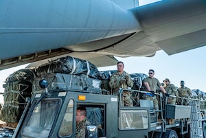 Airmen load pallets of food and water destined for an airdrop over Gaza aboard a C-130J.