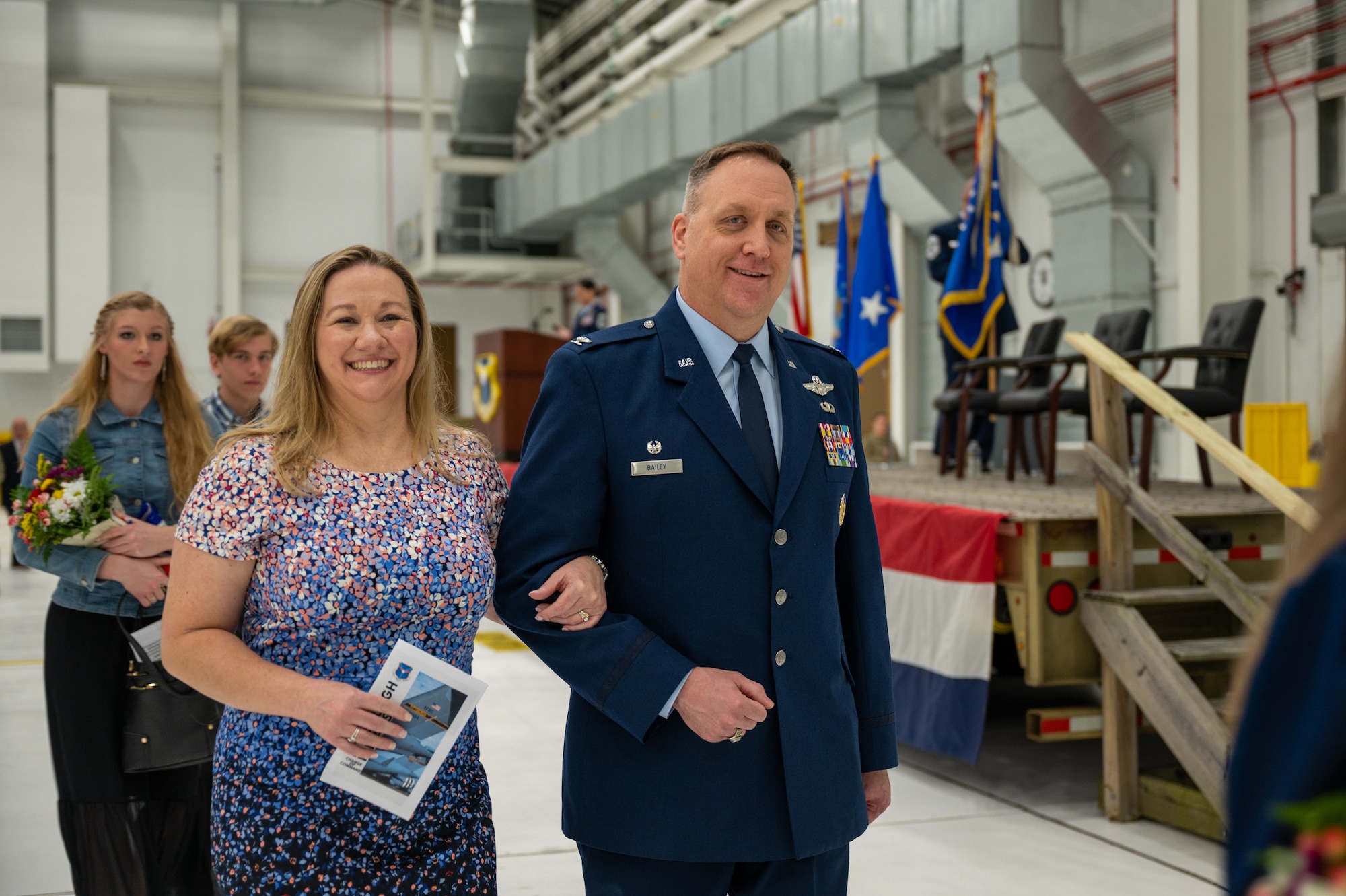 A man in uniform and his wife smile at the camera