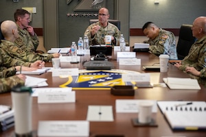 A group of people in U.S. miliary uniforms sitting at a table.