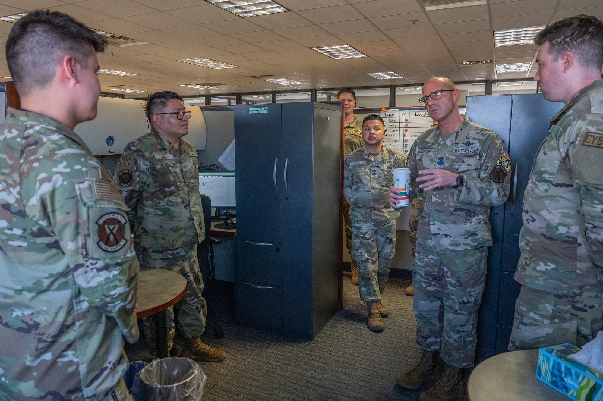A group of people in U.S. miliary uniforms standing in a room.