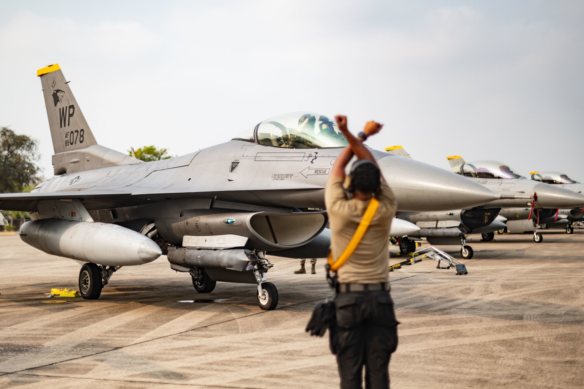 Senior Airman David Flowers, 80th Fighter Generation Squadron dedicated crew chief, marshals an F-16 Fighting Falcon