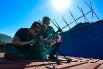U.S. Air Force Senior Airman Justin Moon, a 1st Special Operations Communications Squadron special missions technician, left, and Senior Airman Daniel Chavez, a 1st Special Operations Wing planner, right, set up communications equipment during exercise Tropical Dagger at Kingston, Jamaica, Feb. 21, 2024.