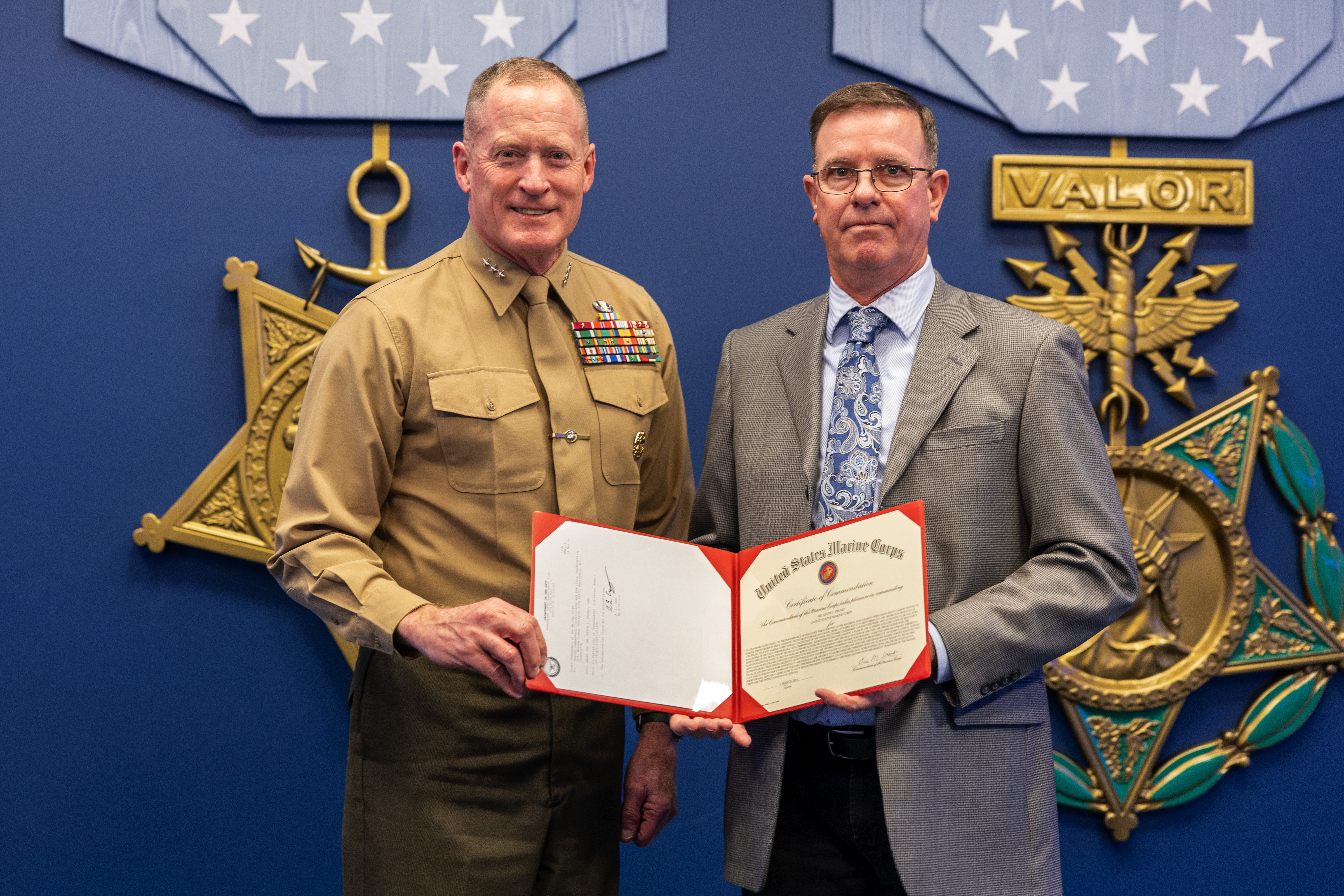 U.S. Marine Corps Lt. Gen. Edward Banta, the Deputy Commandant of Installations & Logistics, presents a certificate to Mr. Keith L. Prusk, the Logistics Command Material Managment Operations Group Liason Officer for 2nd Force Storage Battalion, Marine Forces Reserve at the Pentagon, Washington, D.C. on March 6, 2024. Pruski received the Mr. Nicholas  M. Linkowitz Marine Corps Civilian Logistician of the Year award. (U.S. Marine Corps photo by Lance Cpl. Juaquin Greaves)