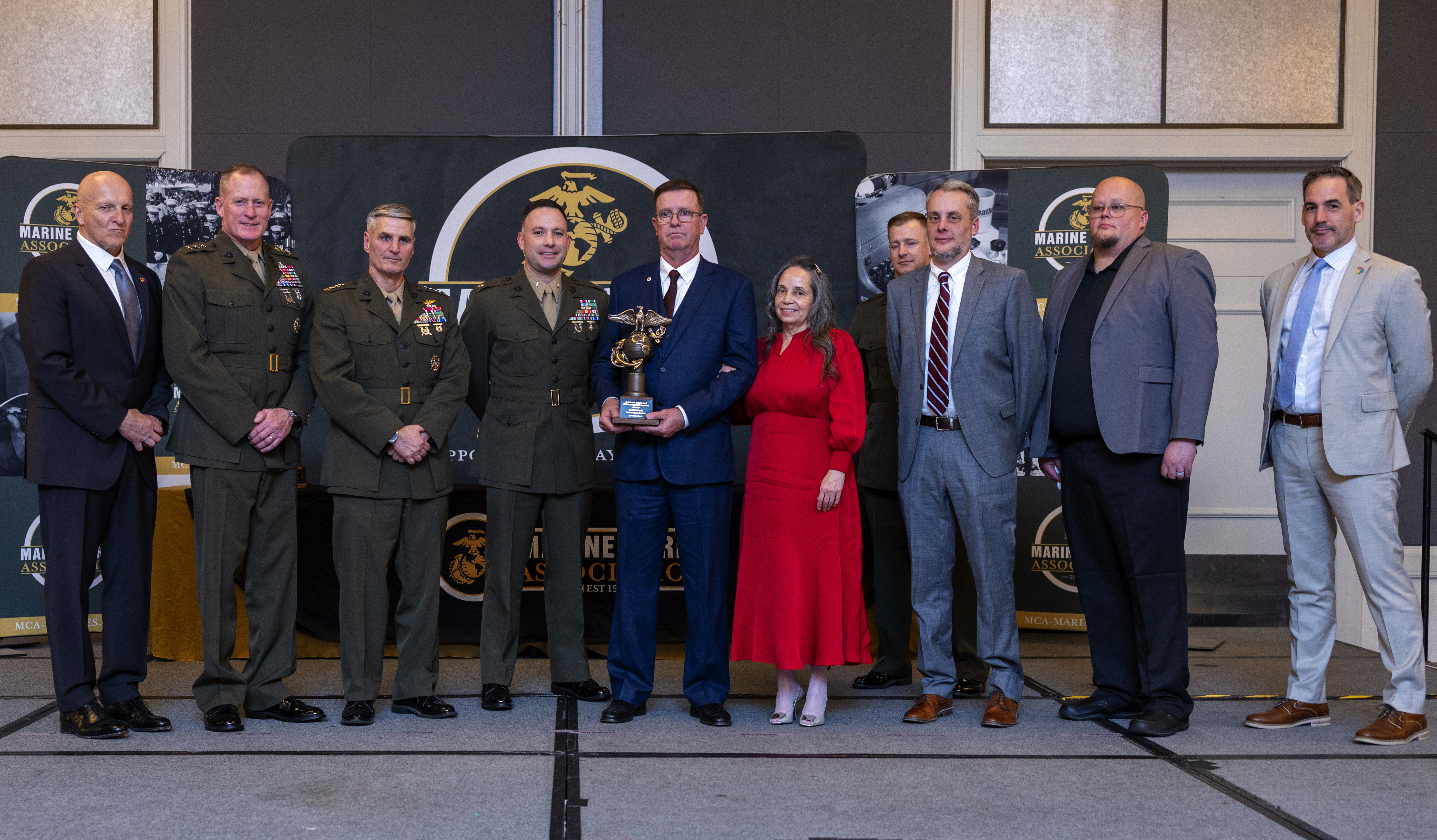 U.S. Marine Corps Gen. Christopher J. Mahnoney, the Assistant Commandant of the Marine Corps, and Lt. Gen. Edward Banta, the Deputy Commandant of Installations and Logistics, presents an award to Mr. Keith L. Pruski, the Logistics Command Material Managment Operations Group Liason Officer for 2nd Force Storage Battalion, Marine Forces Reserve, at the Hilton Alexandria Mark Center, Alexandria, VA on March 6, 2024. Pruski received the Mr. Nicholas M. Linkowitz Marine Corps Civilian Logistician of the Year award. (U.S. Marine Corps photo by Lance Cpl. Juaquin Greaves)
