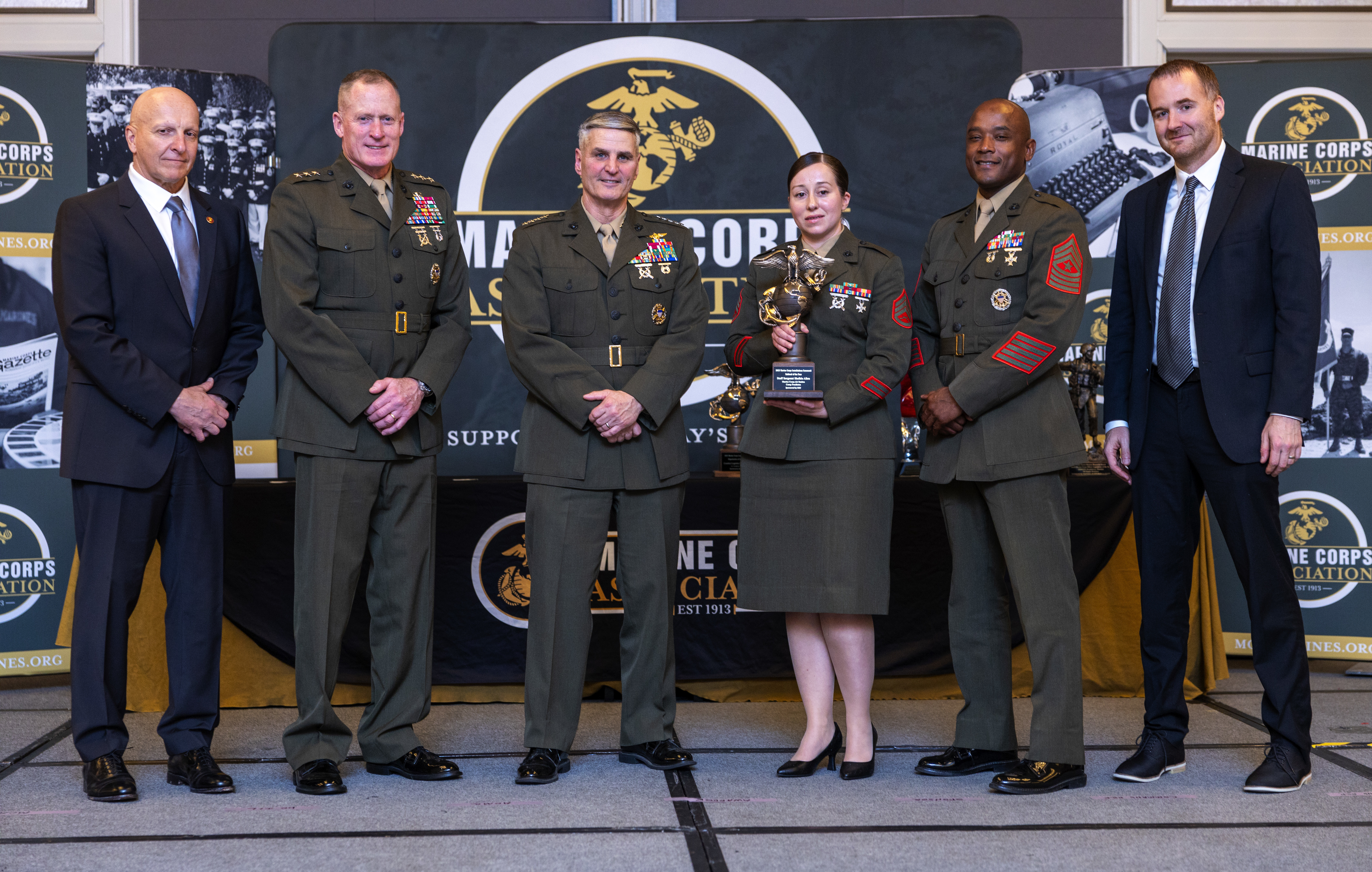 U.S. Marine Corps Gen. Christopher J. Mahoney, the Assistant Commandant of the Marine Corps, and Lt. Gen. Edward Banta, the Deputy Commandant of Installations and Logistics, presents an award to Staff Sgt. Shelbie Allen, the assistant crew chief for Crew Two and Command Sexual Assault and Response Office Victim Advocate for Marine Corps Air Station Camp Pendleton, at the Hilton Alexandria Mark Center, Alexandria, VA on March 6, 2024. Allen received the Marine Corps Installation Command Enlisted Marine of the Year award.  (U.S. Marine Corps photo by Lance Cpl. Juaquin Greaves)