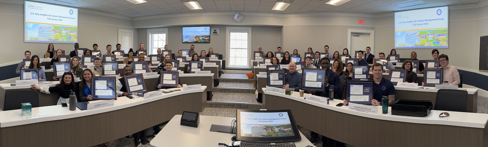 More than 55 participants display their U.S. Navy Insights into Industry Management Course (NIMC) graduation certificates at the University of Virginia, Jan. 2024. The purpose of the three-week course was to communicate to government employees and contract specialists how different industries view the way the Navy does business. (courtesy photo)