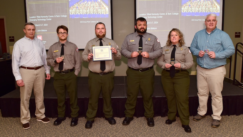 Tim Dunn, U.S. Army Corps of Engineers Nashville District Operations Division deputy chief, presents the Great Lakes and Ohio River Division Water Safety Team Award March 5, 2024, to (Left to Right) Park Rangers Stone Fagan, Hunter Humphrey, Lucas Hix, Ashley Webster, and Resource Manager Kenny Claywell at the Nashville District's Park Ranger Workshop in Paducah, Kentucky. The team is lauded for its promotion of water safety during the 2023 recreation season and the project’s 50th Anniversary activities. Teammates Brad Potts and Nathan Pennington were not able to attend the award presentation. (USACE Photo by Lee Roberts)