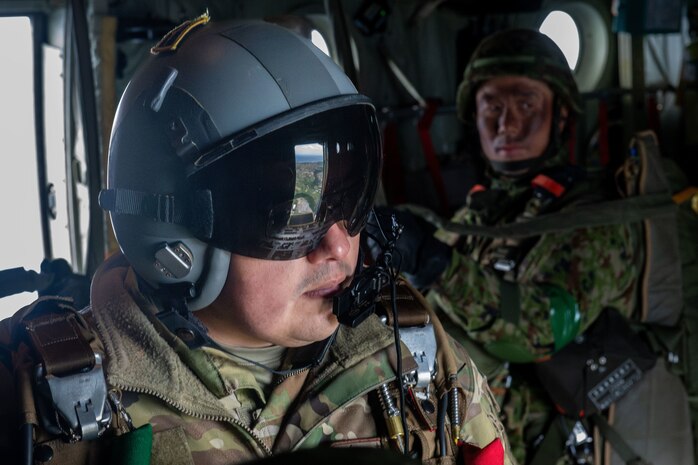 A loadmaster awaits for the signal to drop paratroopers over a drop zone during Airborne 24.