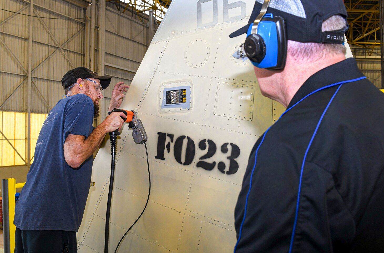 240124-N-DG679-1045
JACKSONVILLE, Fla. (Jan. 24, 2024) 
Sheet Metal Mechanic Troy James, assigned to the Fleet Readiness Center Southeast (FRCSE) F-5 Aircraft Production Line, uses an E-Drill to remove metal fasteners on an F-5 Tiger II vertical stabilizer as Dr. Luis Carney, FRCSE’s senior materials engineer, observes. FRCSE’s F-5 Production Line is the first to implement the E-Drill within the NAVAIR enterprise. The device will significantly reduce the time it takes to remove the thousands of rivets typically replaced during in-depth depot-level maintenance. (U.S. Navy Photo by Toiete Jackson/Release)
