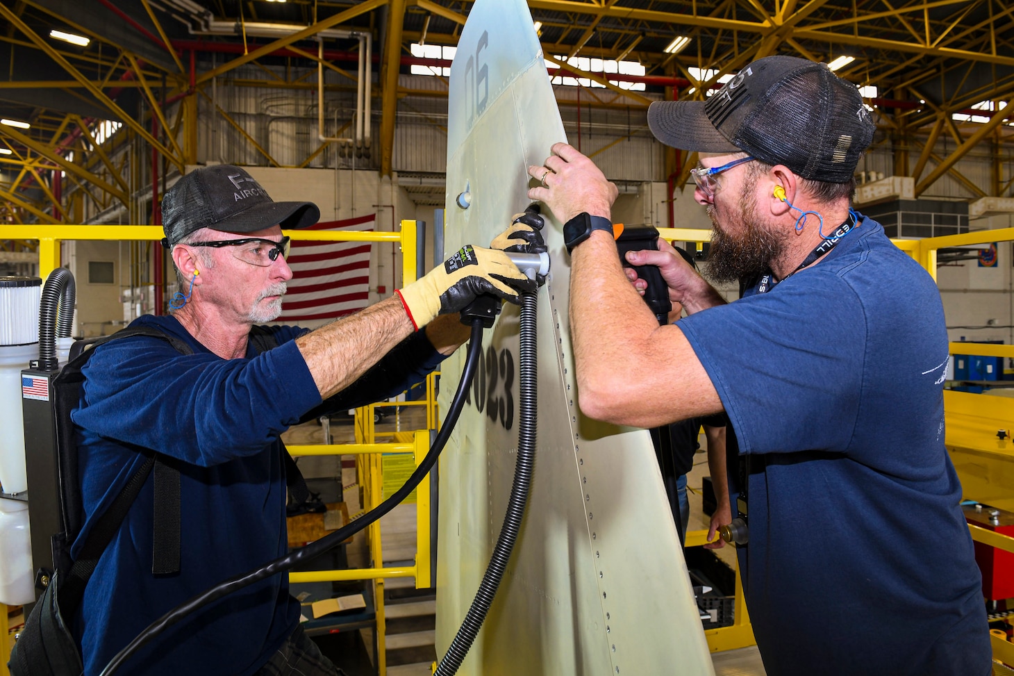 240124-N-DG679-1039
JACKSONVILLE, Fla. (Jan. 24, 2024) 
Sheet Metal Mechanics Mark Sosbe (left) and Troy James (right), assigned to the Fleet Readiness Center Southeast (FRCSE) F-5 Aircraft Production Line, uses an E-Drill system to remove metal fasteners on an F-5 Tiger II vertical stabilizer. FRCSE’s F-5 Production Line is the first to implement the E-Drill within the NAVAIR enterprise. The device will significantly reduce the time it takes to remove the thousands of rivets typically replaced during in-depth depot-level maintenance. (U.S. Navy Photo by Toiete Jackson/Release)