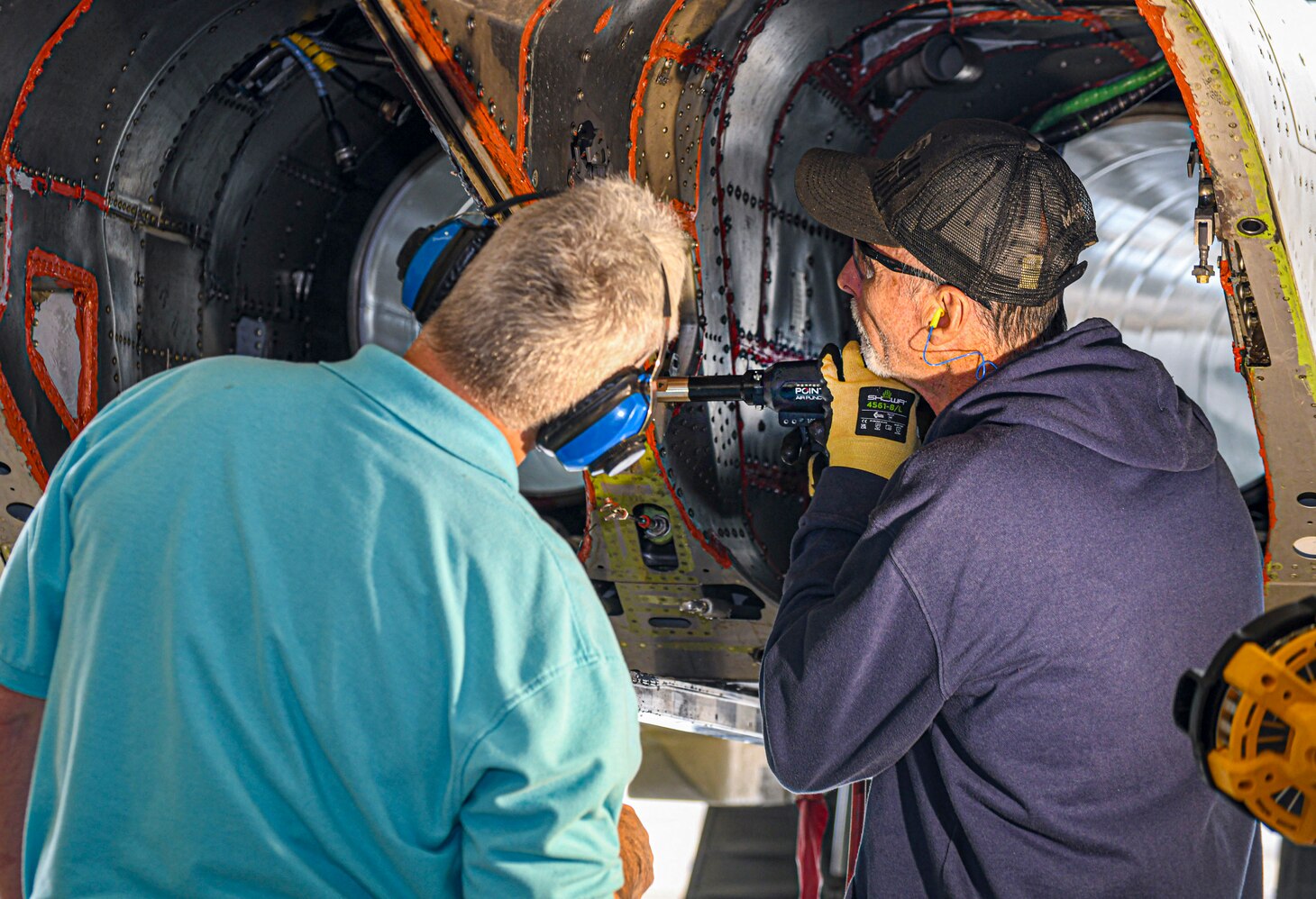 240124-N-DG679-2216
JACKSONVILLE, Fla. (Jan. 24, 2024) 
Sheet Metal Mechanic Mark Sosbe, assigned to the Fleet Readiness Center Southeast (FRCSE) F-5 Aircraft Production Line, uses an E-Drill to remove metal fasteners on an F-5 Tiger II vertical stabilizer as Dr. Luis Carney, FRCSE’s senior materials engineer, observes. FRCSE’s F-5 Production Line is the first to implement the E-Drill within the NAVAIR enterprise. The device will significantly reduce the time it takes to remove the thousands of rivets typically replaced during in-depth depot-level maintenance. (U.S. Navy Photo by Toiete Jackson/Release)