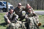 Georgia Defense Force Junior Sergeant Paata Sabiashvili, front left, an infantryman representing the 1st Infantry Brigade; Georgia Defense Force Corporal-Specialist Irakli Nozadze, front right, a cannon crewmember representing the 5th Artillery Brigade; 1st Sgt. Sergo Kandelaki, back left, executive assistant to the Georgia Defense Force Command Sergeant Major, Georgia Defense Force General Staff; and Staff Sgt. Michael Tenoshcok, back right, Joint Operation Center noncommissioned officer, Joint Force Headquarters, Georgia National Guard; pose for a photo during the 2024 Georgia Army National Guard State Best Warrior Competition at the Catoosa Volunteer Training Site, Ringgold, Georgia, March 12, 2024.