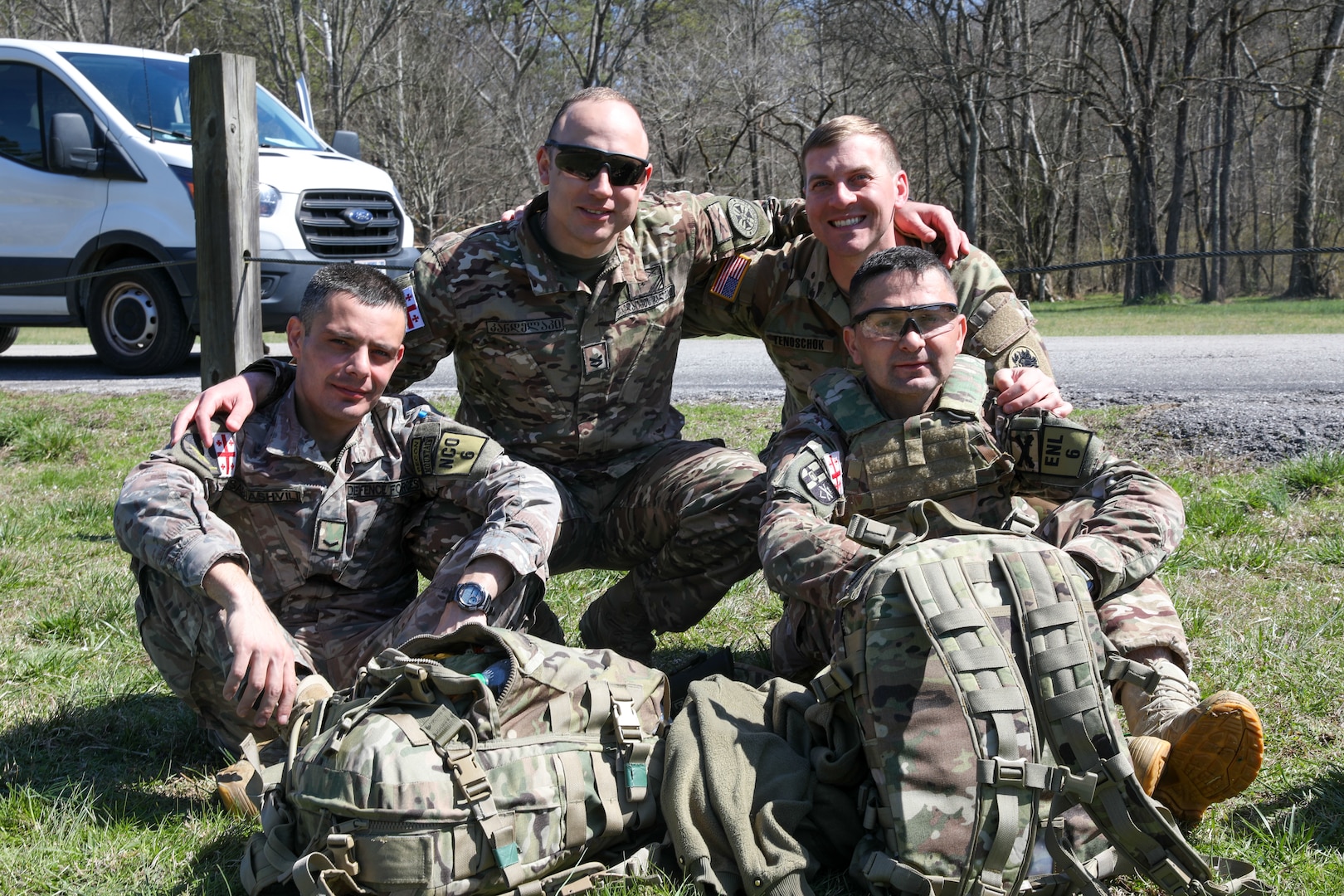 Georgia Defense Force Junior Sergeant Paata Sabiashvili, front left, an infantryman representing the 1st Infantry Brigade; Georgia Defense Force Corporal-Specialist Irakli Nozadze, front right, a cannon crewmember representing the 5th Artillery Brigade; 1st Sgt. Sergo Kandelaki, back left, executive assistant to the Georgia Defense Force Command Sergeant Major, Georgia Defense Force General Staff; and Staff Sgt. Michael Tenoshcok, back right, Joint Operation Center noncommissioned officer, Joint Force Headquarters, Georgia National Guard; pose for a photo during the 2024 Georgia Army National Guard State Best Warrior Competition at the Catoosa Volunteer Training Site, Ringgold, Georgia, March 12, 2024.