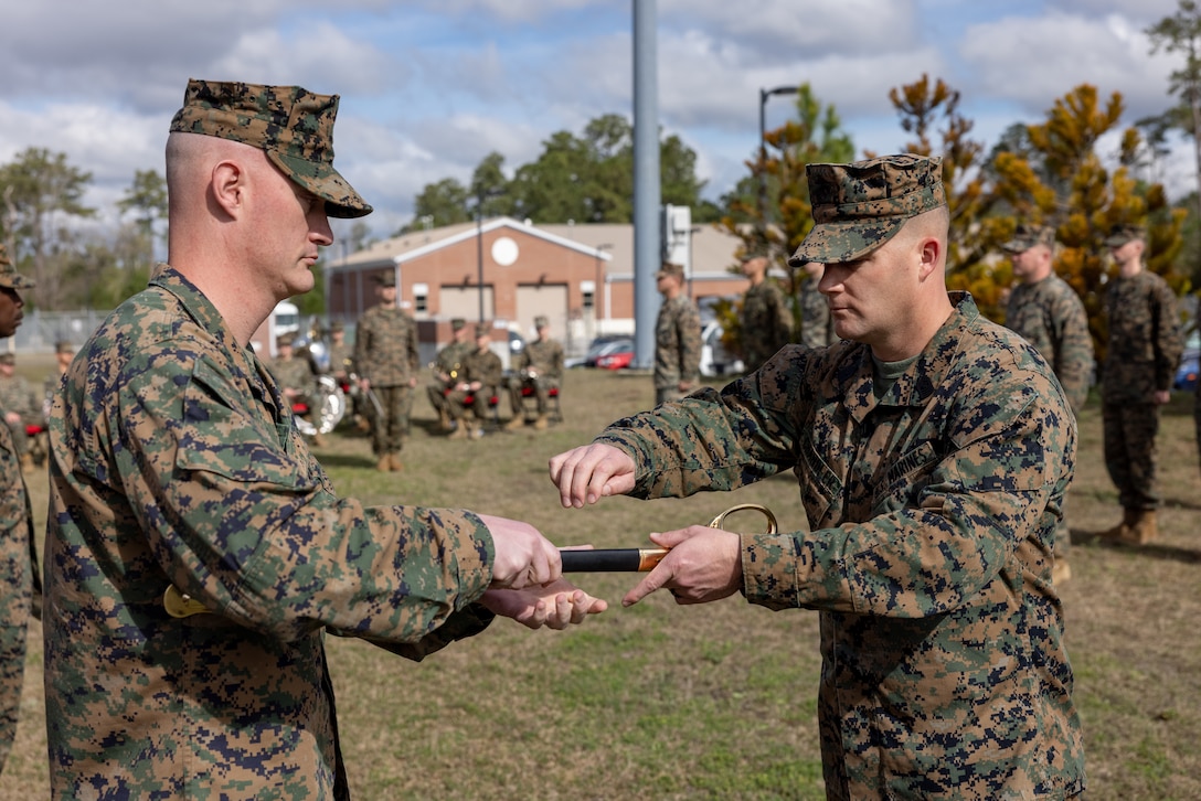 U.S. Marine Corps Lt. Col. Andrew S. Walker, left, commanding officer, 2nd Network Battalion, hands a non-commissioned officer sword to Sgt. Maj. Casey S. Chandler, incoming sergeant major for 2nd Network Battalion, during a relief and appointment ceremony on Marine Corps Base Camp Lejeune, North Carolina, March 8, 2024.